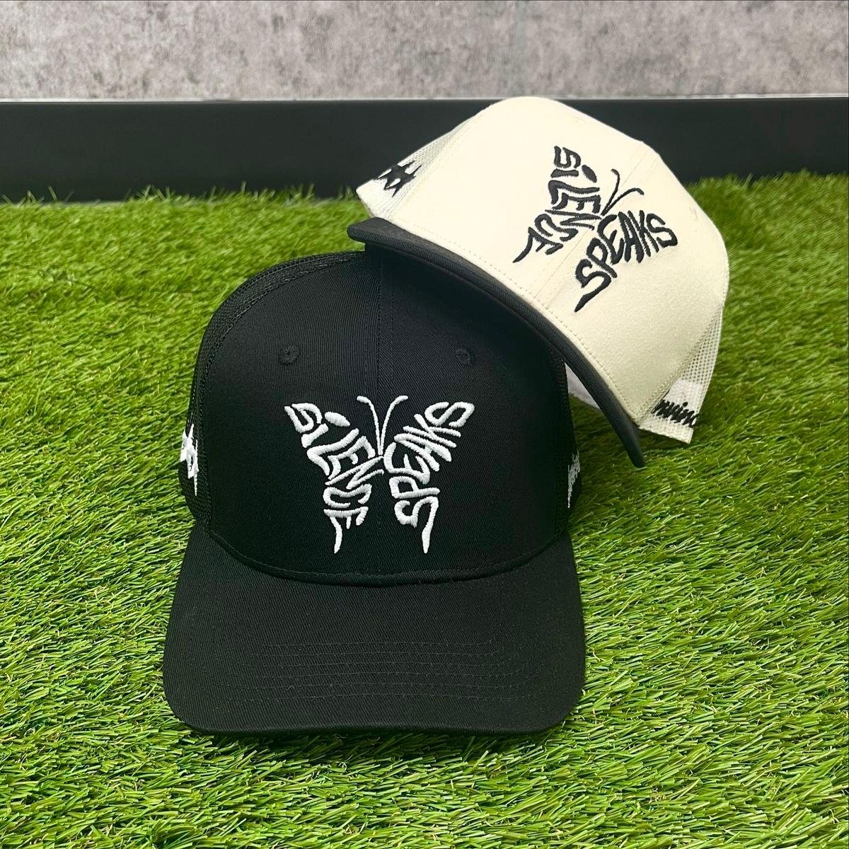 Custom black and cream trucker caps with butterfly embroidered logos